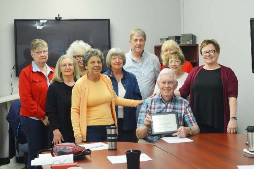 Alex McLeod (bottom right) receving a plaque tomark 24 years as a Food Bank volunteer